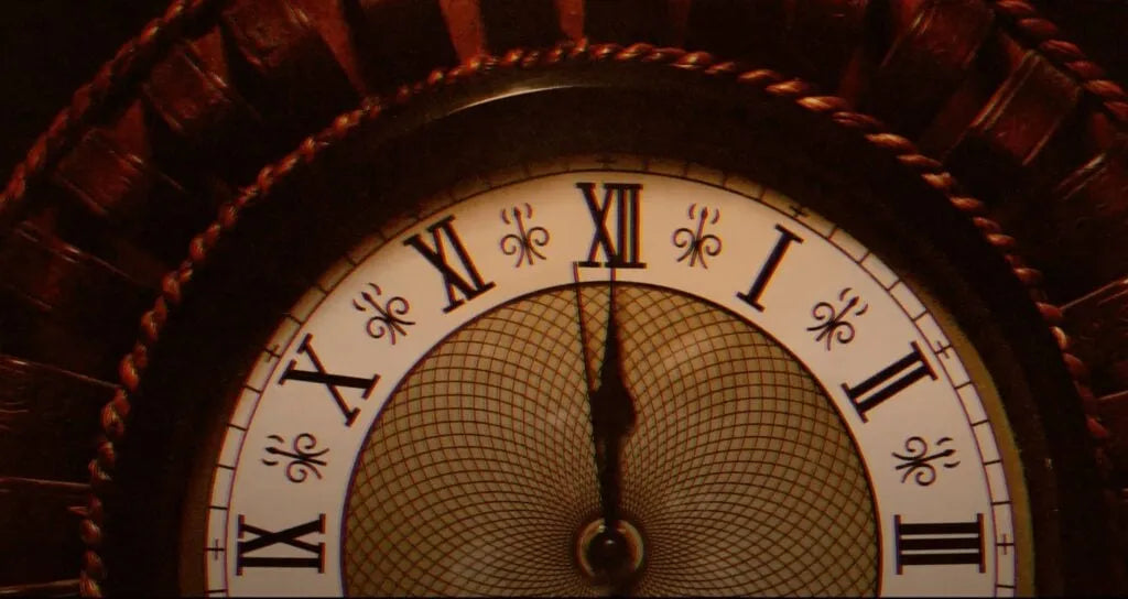 Das Zifferblatt einer antiken Uhr, die Zeiger auf zwölf