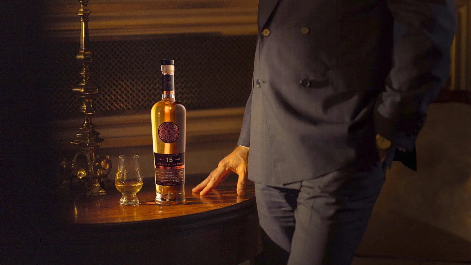 Eine Flasche One Cask at a Time in ihrer Box neben einem Glas auf einem polierten Tisch
